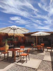 a group of tables and chairs with umbrellas at Pirca Hostal in San Pedro de Atacama