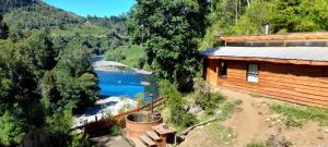 a log cabin with a view of a river at cabaña trafwe in Lago Ranco