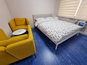 仁川的住宿－Bluehum Guest house，一间卧室配有一张床、一张沙发和一把椅子