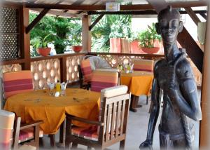 a statue of a woman sitting at a table in a restaurant at Hotel Aurore Lomé in Lomé