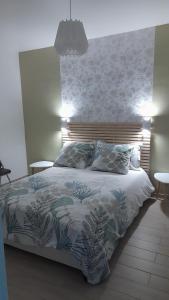 1 dormitorio con 1 cama grande con colcha de flores en Evasion45 en Étauliers