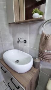baño con lavabo blanco en la encimera en Apartamento Praia Grande, en Praia Grande