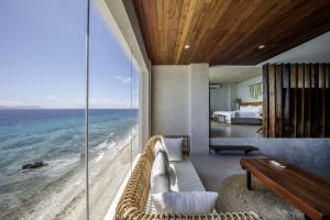 a bedroom with a view of the ocean at Burgos Reef Boutique Resort in Padre Burgos