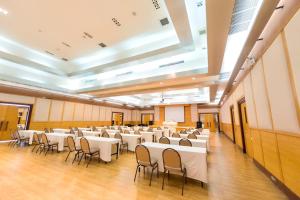 un gran salón de banquetes con mesas y sillas blancas en Uniland Golf & Resort en Nakhon Pathom