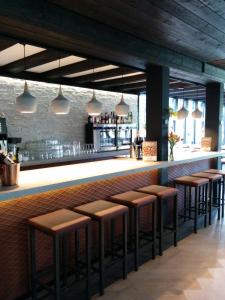 a bar with brown stools in a restaurant at Hotel Bieze in Borger