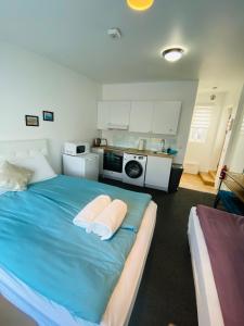 a bedroom with a blue bed with two white pillows at Easy Stay in Keflavík