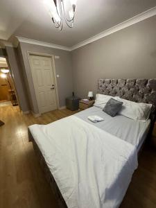 a bedroom with a large white bed with a headboard at A 2 standard bedrooms flat in London