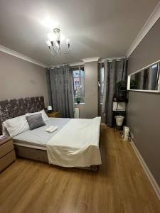 a bedroom with a large bed and a wooden floor at A 2 standard bedrooms flat in London