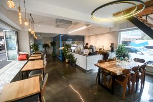 Bluehum Guest house في انشيون: مطعم بطاولات وكراسي خشبية وكاونتر