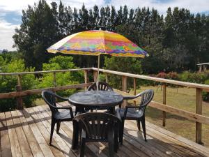 a table and chairs under an umbrella on a deck at pansy in Joubertina