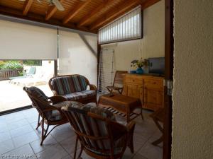 ein Wohnzimmer mit Stühlen, einem Sofa und einem TV in der Unterkunft Maison La Palmyre, 4 pièces, 5 personnes - FR-1-705-29 in La Palmyre