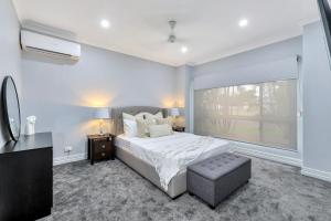a bedroom with a large bed and a window at The OC Home: Centrally Located, Home Away Home in Nightcliff
