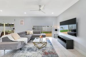 a living room with a couch and a tv at The OC Home: Centrally Located, Home Away Home in Nightcliff