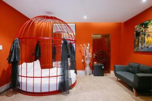 Khách Sạn Nhà Mình في Cái Răng: غرفة برتقالية مع قفص الطيور في غرفة المعيشة