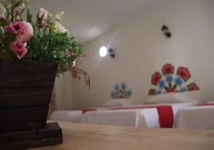 1 dormitorio con 2 camas y un jarrón de flores sobre una mesa en Mia Bonita Hotel Boutique, en Tararameo