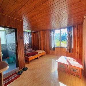 ein Zimmer mit einem Bett und ein Zimmer mit einem Fenster in der Unterkunft Lali Gurash Homestay - Okhrey in Sombāri