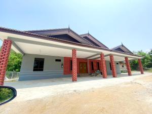 uma casa com pilares de tijolos vermelhos em frente em Sasuka Guesthouse (Muslim Sahaja) em Marang