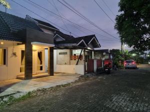 日惹Giori Rice Field View Syariah的街道旁有停车位的房子