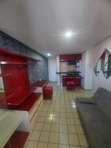 uma grande cozinha com armários vermelhos e bancos vermelhos em Flat Number One - Ponta D'areia - Ferreira Hospedagens em São Luís