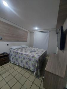 a bedroom with a bed and a flat screen tv at Flat Number One - Ponta D'areia - Ferreira Hospedagens in São Luís