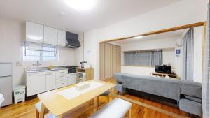 a kitchen with a couch and a table in a room at Suminchu House Ichariba in Naha