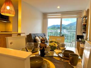 ein Wohnzimmer mit einem Tisch und Weingläsern in der Unterkunft Espectacular vista cerca a cable plaza con Piscina in Manizales