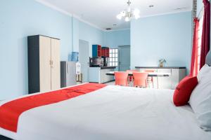 uma grande cama branca num quarto com uma cozinha em RedDoorz Plus @ Jalan Iskandar Muda Medan em Medan