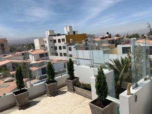 Cayma, hermoso dpto. completo con terraza في أريكيبا: إطلالة على المدينة من شرفة مع أشجار الفخار