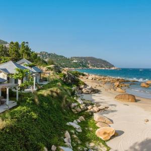 a house on the beach next to the ocean at Quy Nhon Pearl - FLC Sea Tower in Quy Nhon