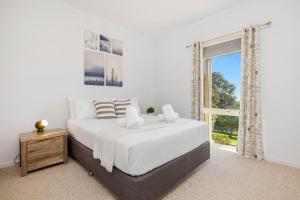 Un dormitorio blanco con una cama grande y una ventana en Sunset Views, en McCrae