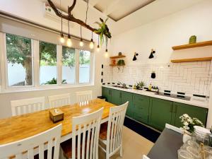 a kitchen with a wooden table and green cabinets at Contemporary Greenhouse Garden Villa- 4 bedrooms Villa in Vung Tau