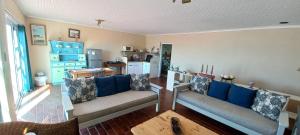 a living room with two couches and a kitchen at Pik 'n Wyntjie in Gansbaai