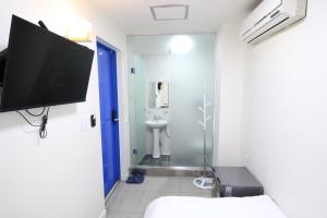 a bathroom with a tv on the wall and a toilet at Stay in Blue in Seoul