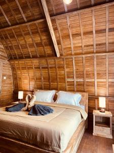 a bed in a wooden room with two lamps at Jordan Guest House in Uluwatu