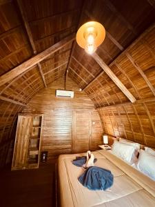 a woman laying on a bed in a room at Jordan Guest House in Uluwatu