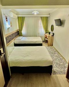 a hotel room with two beds and a table at Kestanbol Hotel in Çanakkale