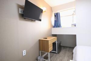 a room with a bed and a tv on the wall at Stay in Blue in Seoul