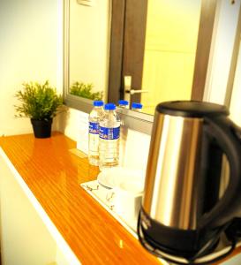 a counter with two bottles of water and a coffee pot at Kestanbol Hotel in Çanakkale