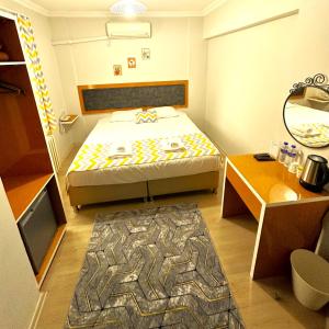Habitación pequeña con cama y espejo. en Kestanbol Hotel, en Canakkale