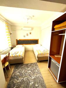 Habitación pequeña con 2 camas y alfombra. en Kestanbol Hotel, en Canakkale