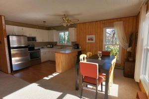 a kitchen with a table and chairs and a refrigerator at Peaceful & Private Cabin close to the Lake in Matlock