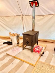 a stove sitting on the floor next to a tent at Golden Point Glamping in Faraday