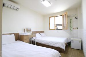 une chambre avec deux lits et une fenêtre dans l'établissement Stay in Blue, à Séoul