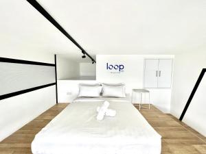 a white room with a white bed and a stool at KL Sentral Serviced Apartment - The Establishment KL Sentral by Loop Suites in Kuala Lumpur