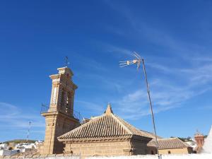 un edificio con una torre de reloj y un molino de viento en Fantástico duplex en el centro de Osuna en Osuna