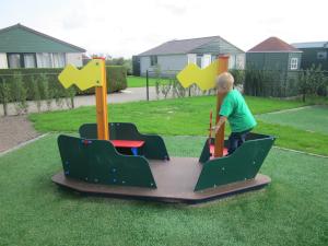 a young boy playing on a play set in a yard at Vakantiepark Zijpersluis in Burgerbrug