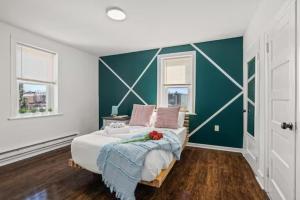 a bedroom with a bed with a green accent wall at Cozy&Chic Apartments Near Downtown in Philadelphia