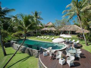 un complejo con una piscina con sillas y sombrillas en Sungai Tinggi Beach Villa by Elite Havens, en Canggu