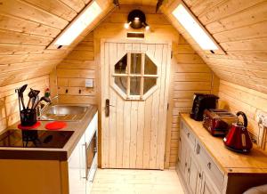 eine Küche mit einem Waschbecken und einer Tür in einer Hütte in der Unterkunft Seal Cove Cabin - Luxury Glamping in Cairndow