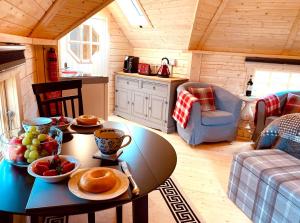 eine Küche mit einem Tisch mit Pfannkuchen und Obst darauf in der Unterkunft Seal Cove Cabin - Luxury Glamping in Cairndow